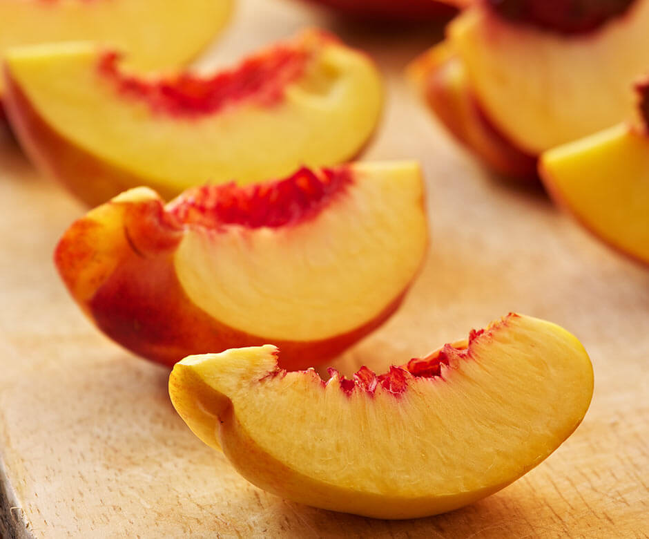 Fresh peaches being prepped to be frozen