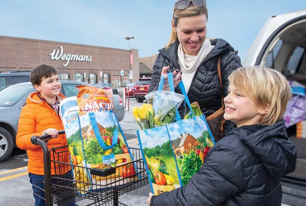 family holding groceries in reusable bags